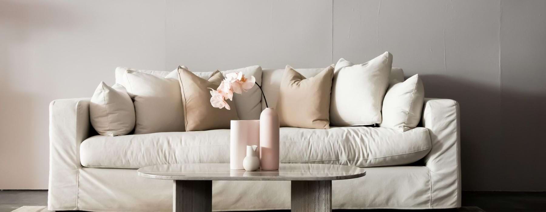 living room with a large couch and vases on a coffee table