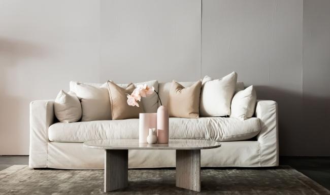 living room with a large couch and vases on a coffee table
